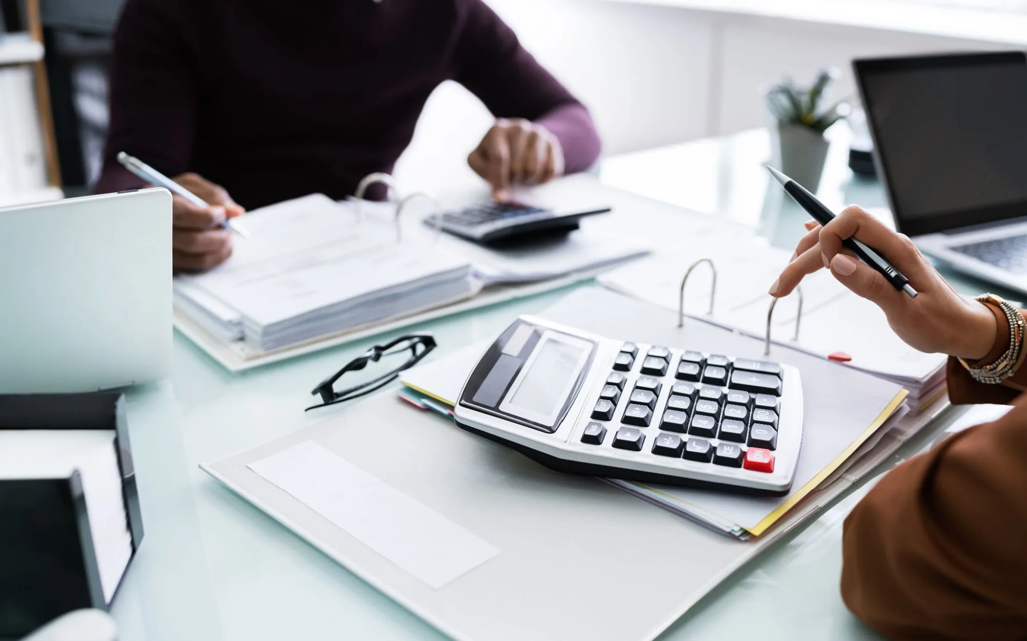 Hands with a calculator and documents on a desk