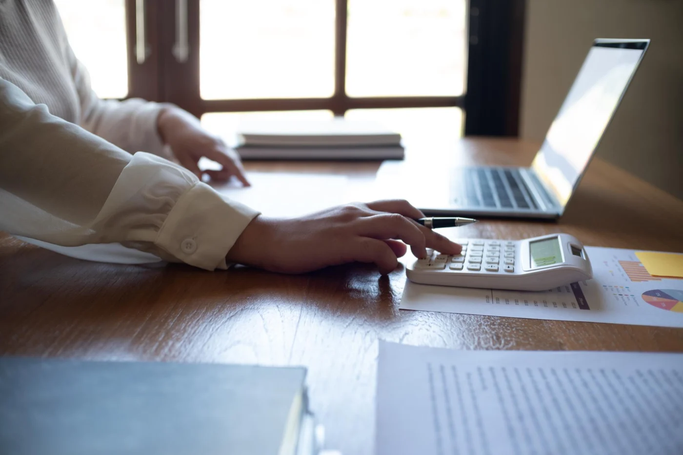 A bookkeeper working through invoices and documents at a desk
