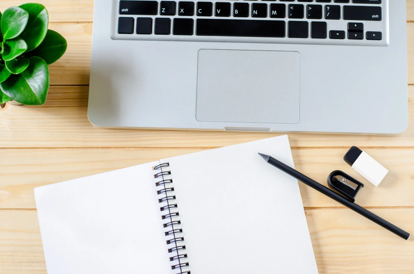 A tidy onboarding checklist and laptop on a desk in a bright office