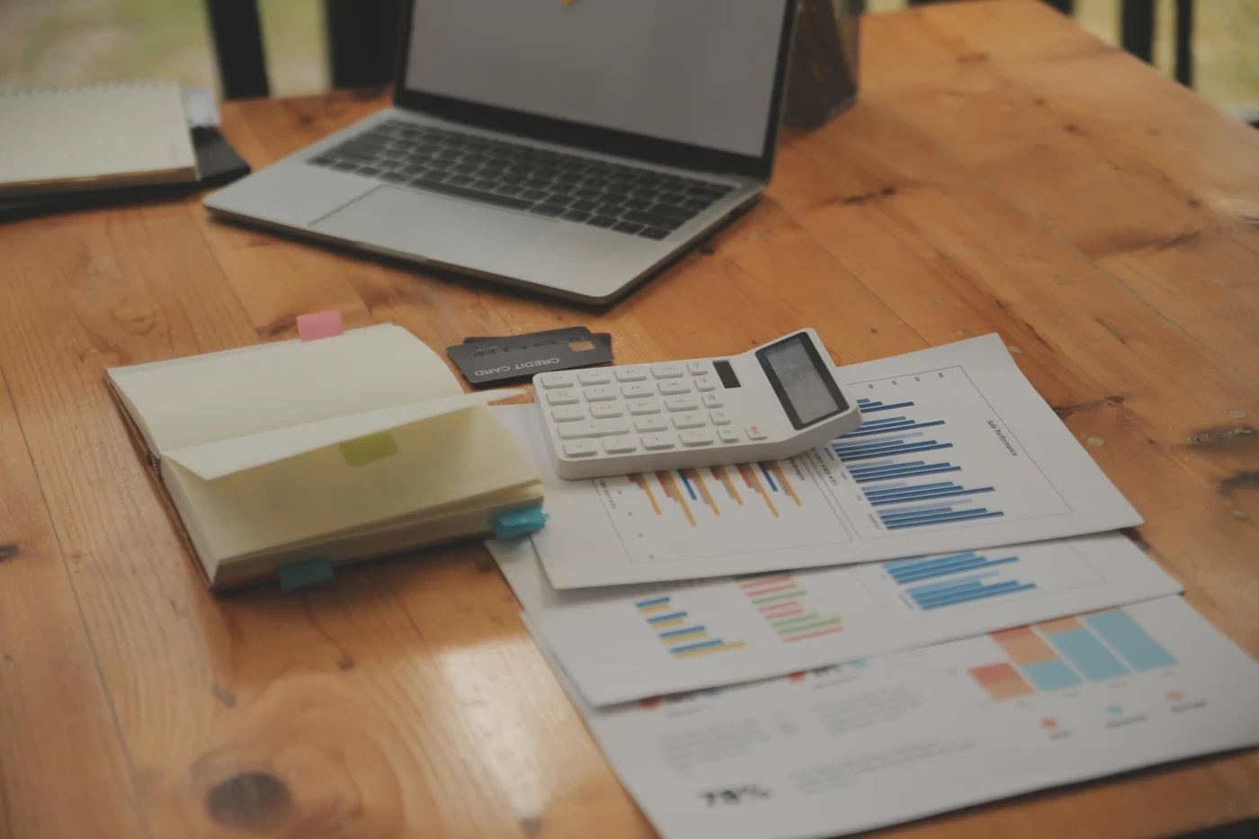 A calculator and financial charts on a desk