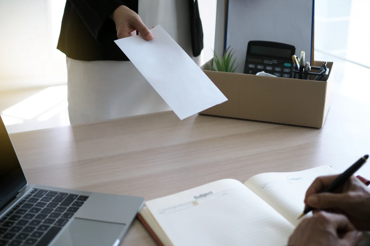 Business records and a laptop being handed across a desk during an accountant handover