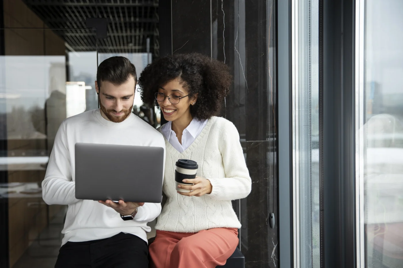 A team collaborating around a laptop in an Isle of Man office