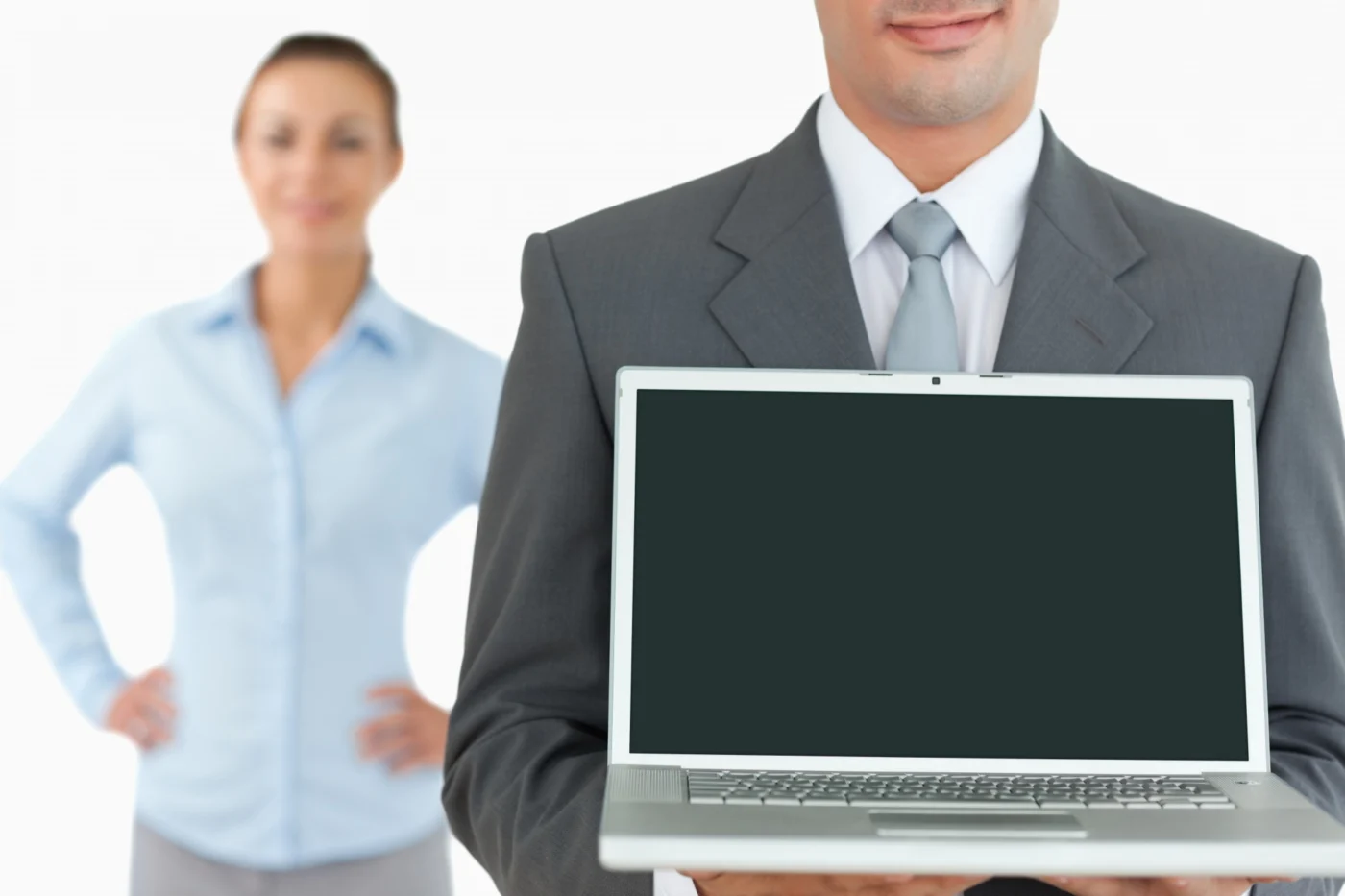 Two professionals reviewing company figures on a screen in an office