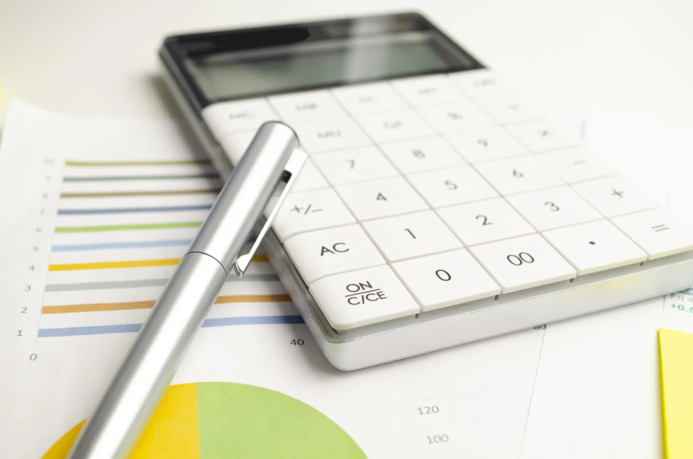 Close-up of financial statements and a calculator with a pen