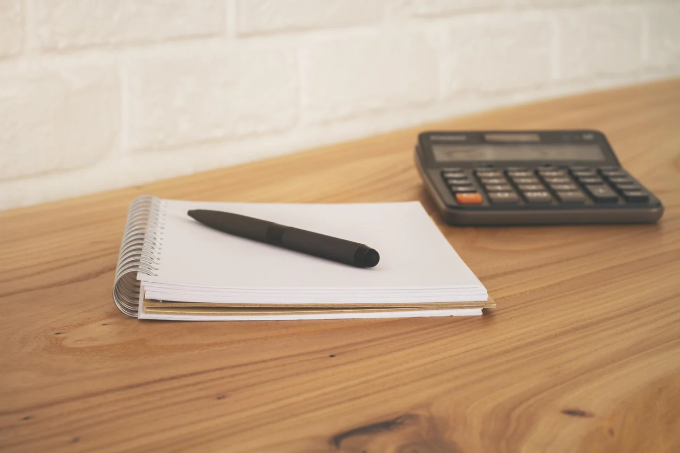 A close-up of a payslip, calculator and spreadsheet on a desk