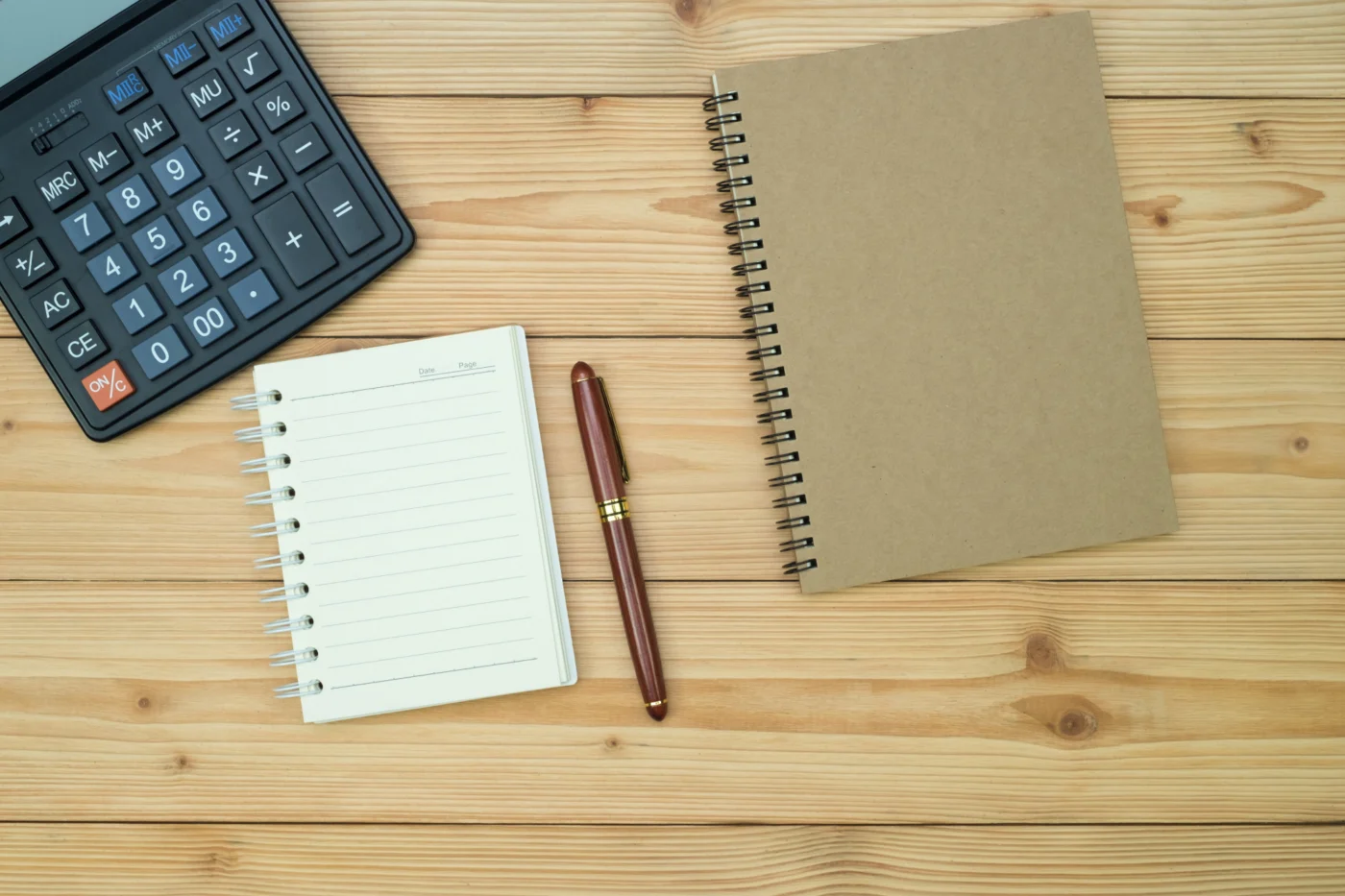 A calculator and notebook on a desk for budgeting self-employed income