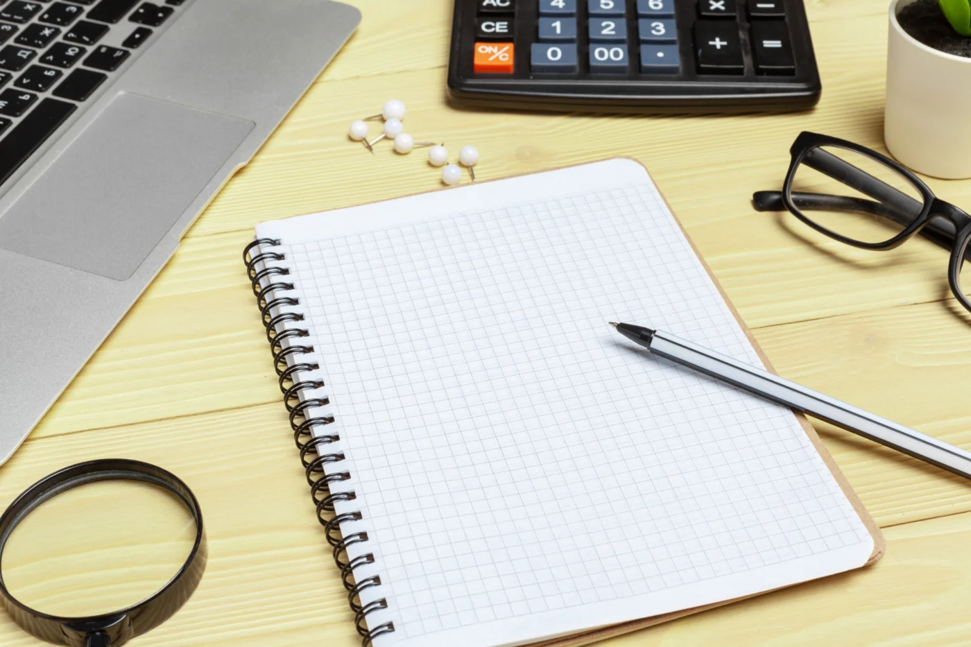 An accountant and a company director reviewing bound company accounts across a desk