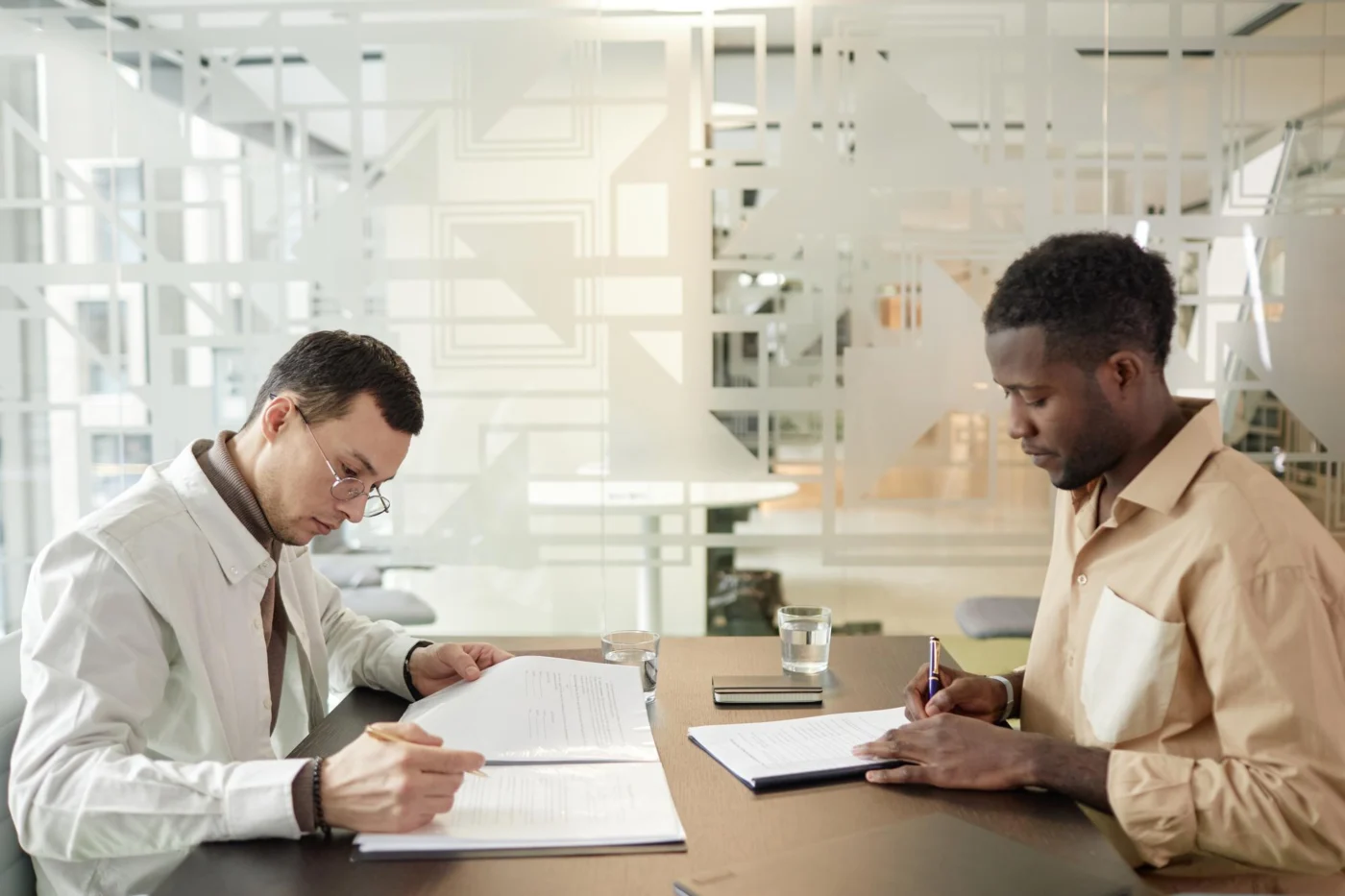 A business owner and adviser going through employment paperwork