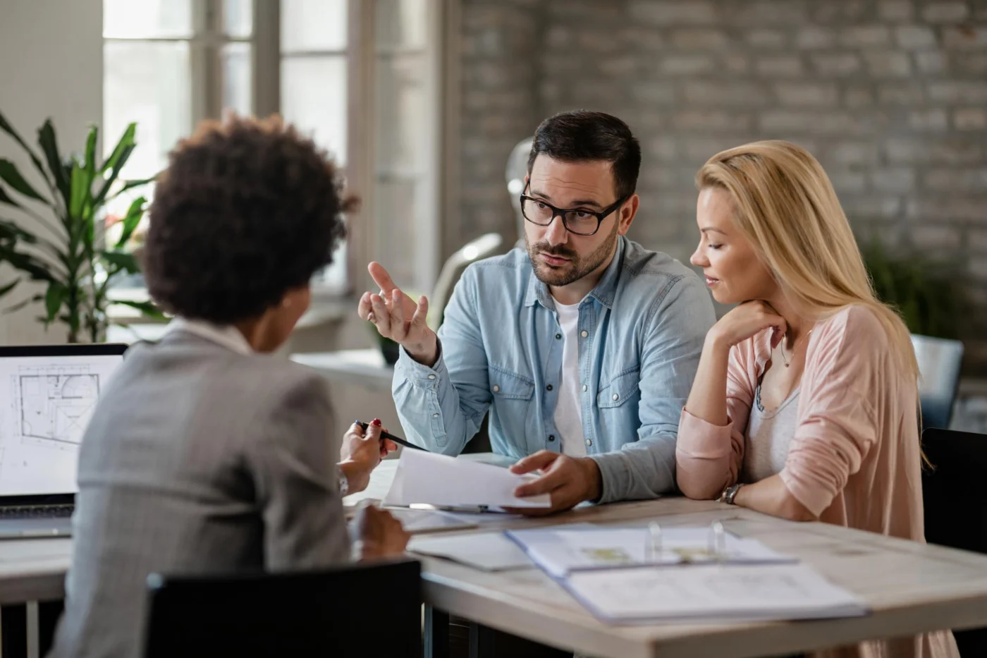Two people discussing a property investment over documents