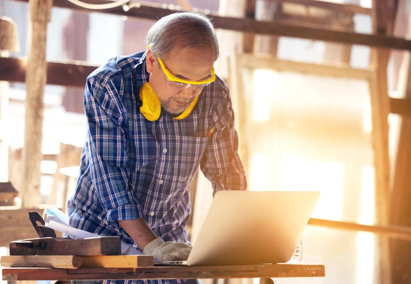 A self-employed tradesperson reviewing accounts on a laptop