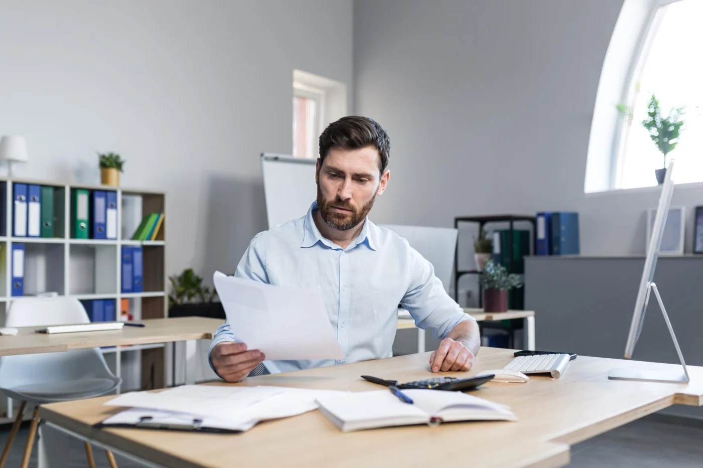A business owner working through tax return paperwork at a desk