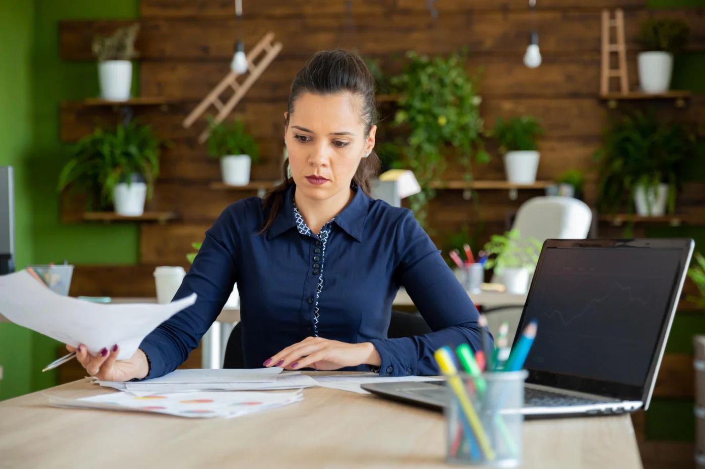 A finance officer prepares year-end payroll forms at her desk