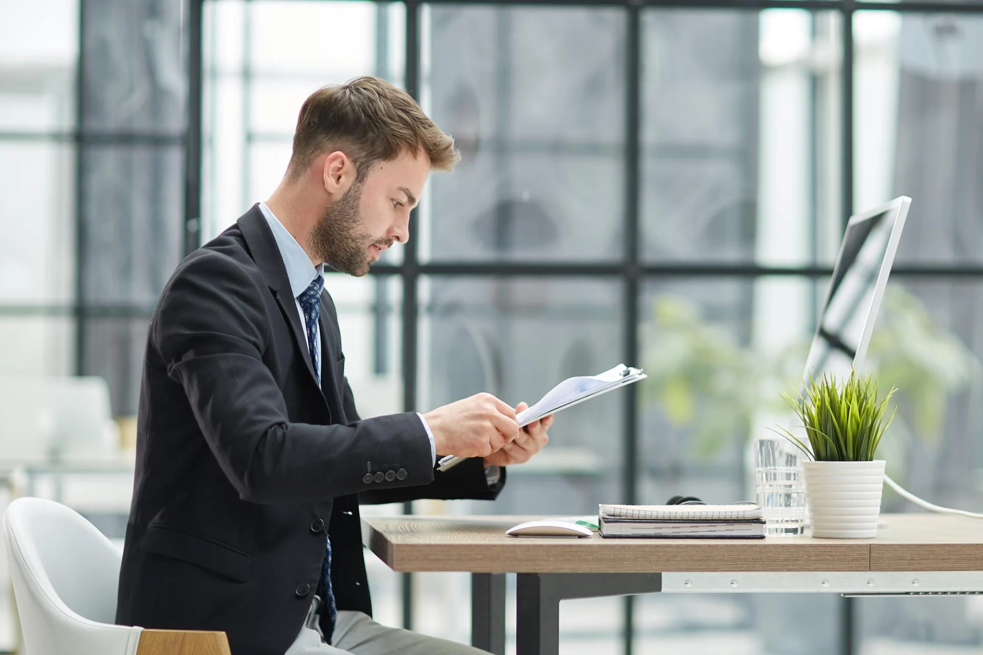 A business owner reading guidance documents at an office desk