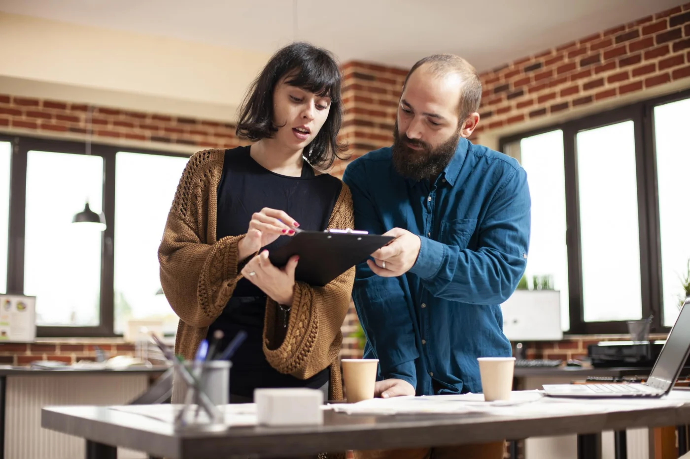 Two colleagues check a tariff sheet on a clipboard together