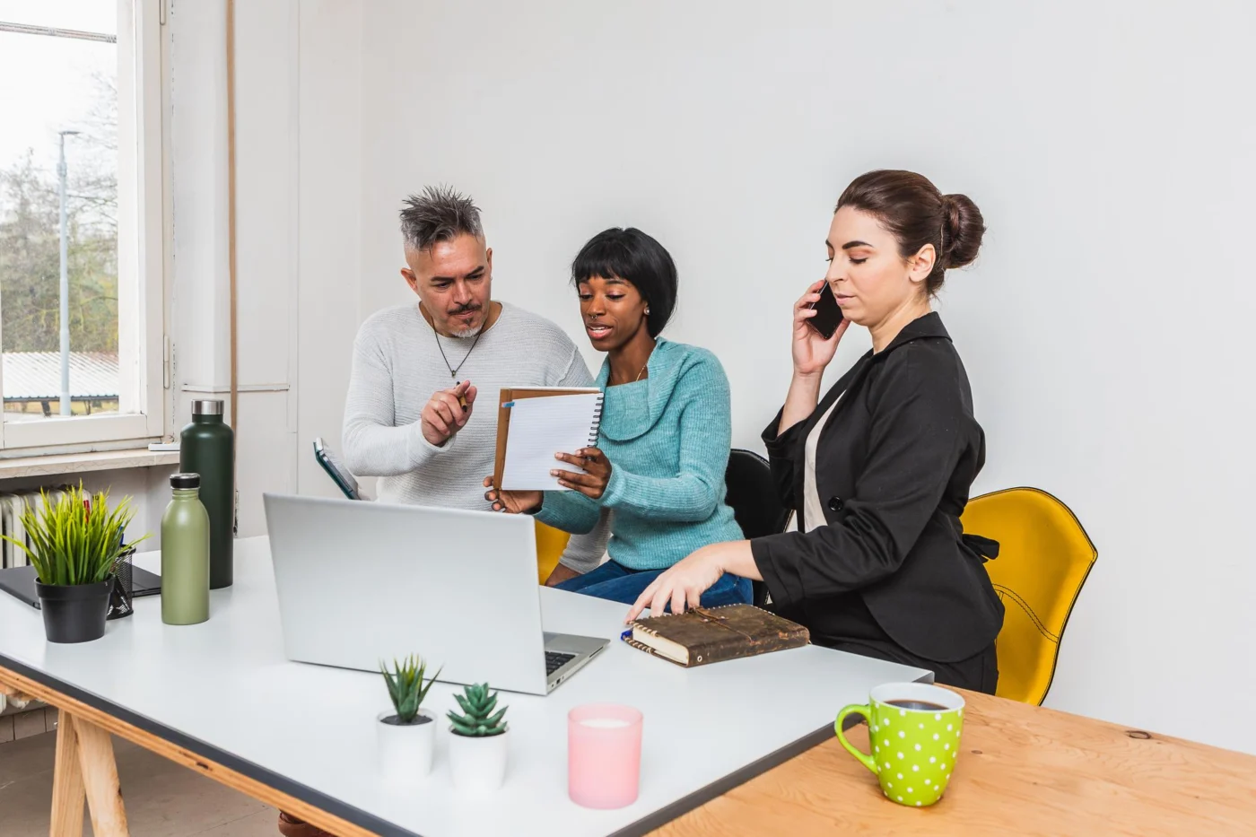 Colleagues go through a weekly work schedule together at a desk