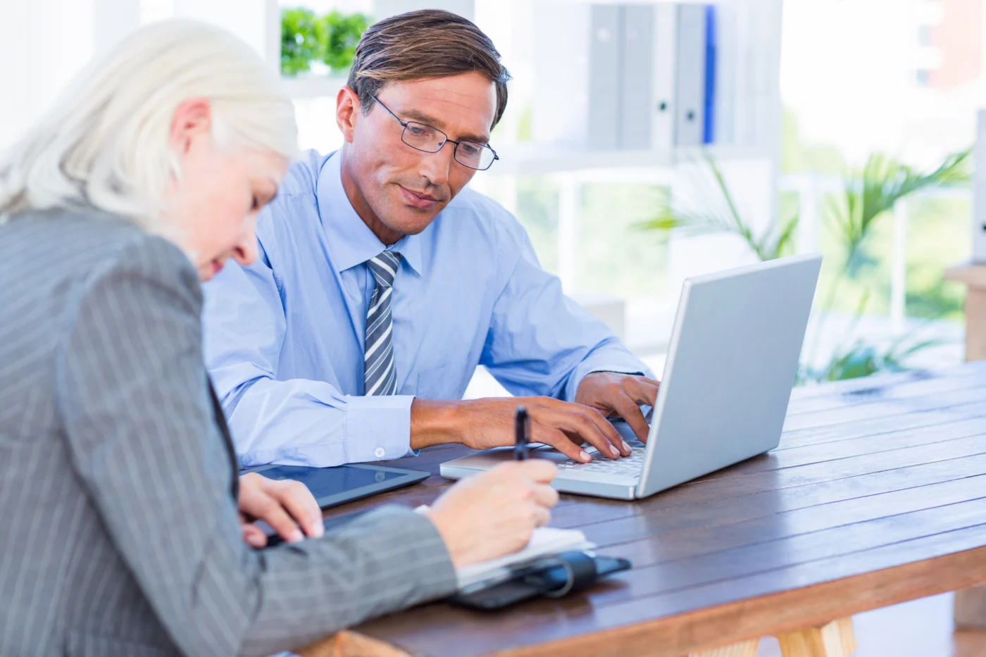 An adviser and a client go through a budget together in an office