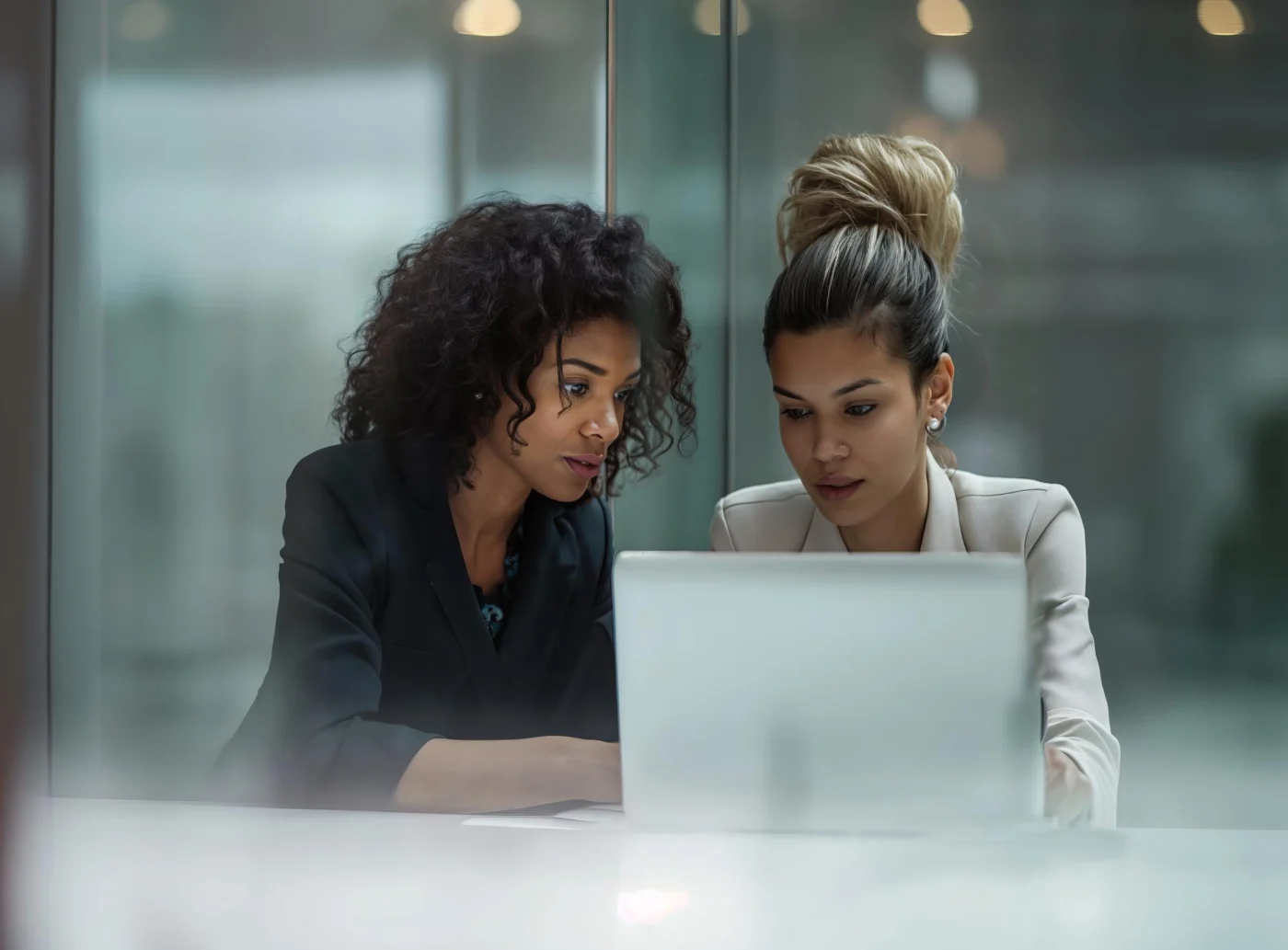 Two colleagues look together at a tax calculation on a laptop