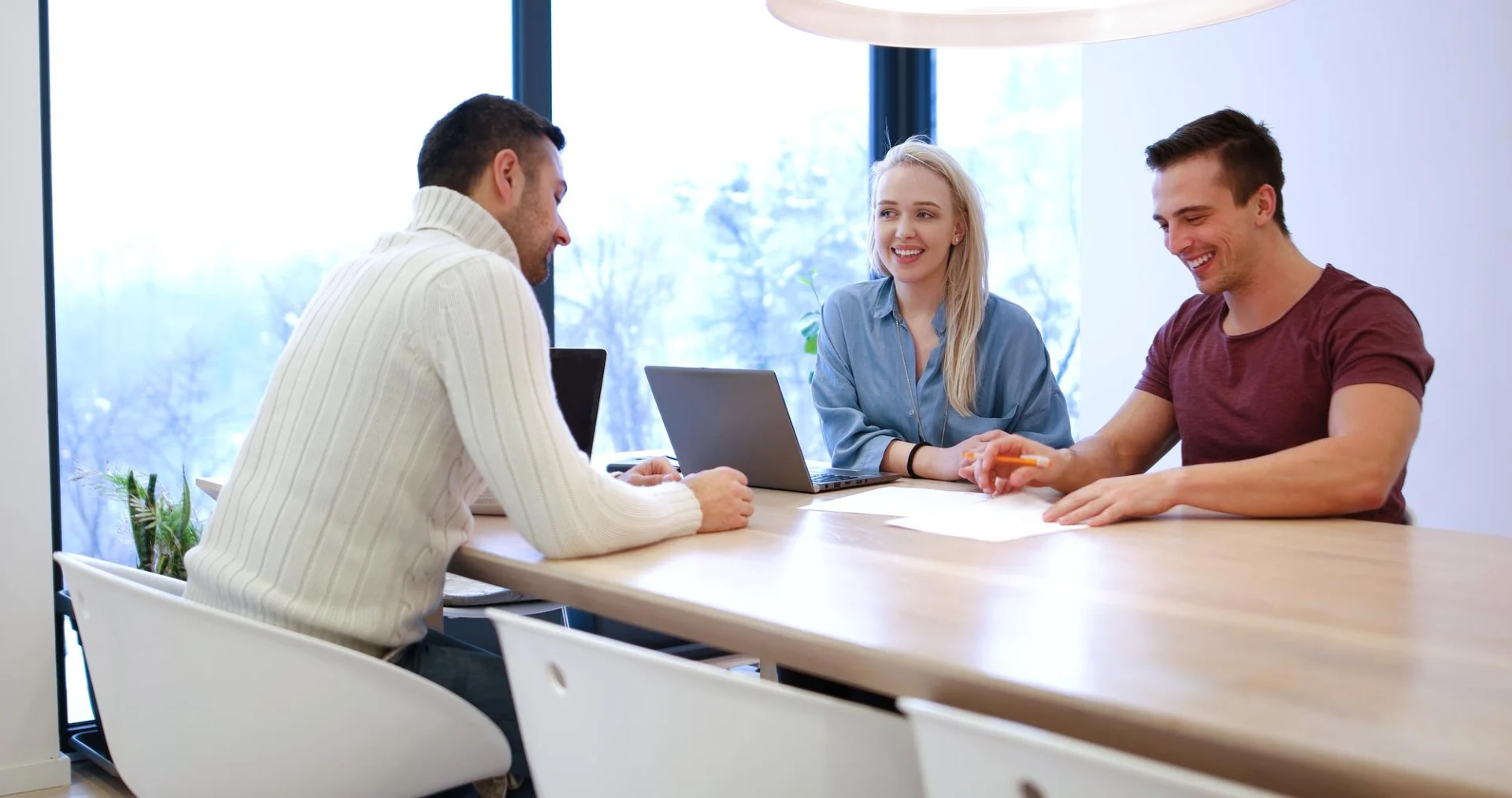 An adviser meets a couple across a conference table to discuss their move